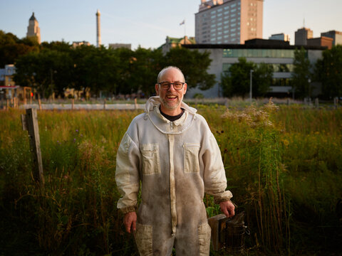 A portrait of an urban beekeeper at sunset