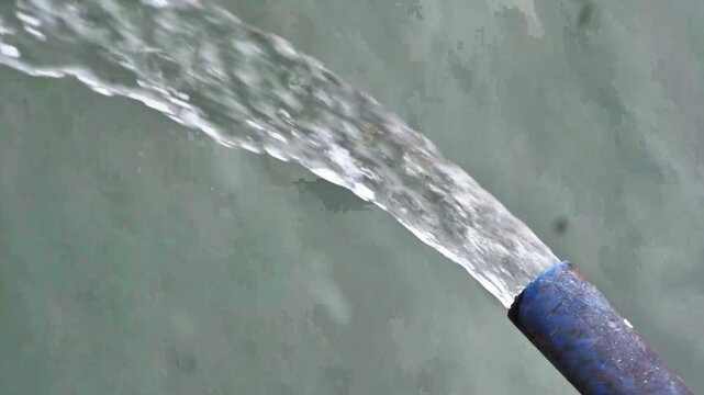 A close-up of flowing water from a water drainage pipe