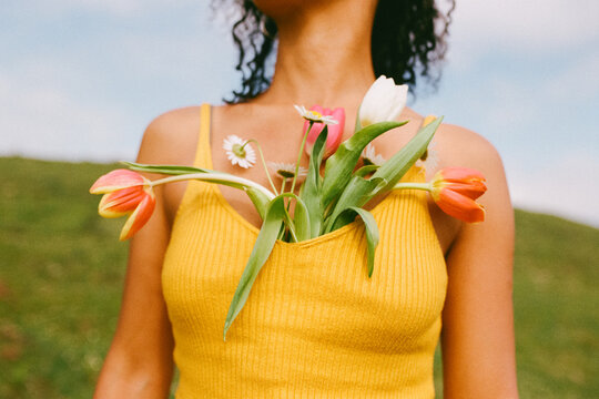 Woman with flowers in her shirt on a sunny day in the field