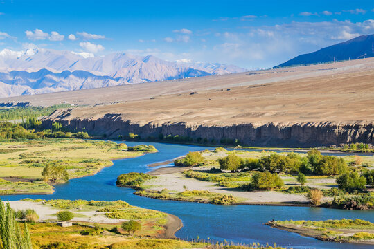 Indus river flowing through green Leh valley, near Leh Airport, Ladakh, India. Leh is capital of Ladakh, Jammu and Kashmir and known for natural landscape attracting tourists from all over world.
