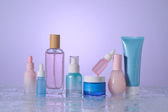 Cosmetic products arranged on a wet surface, ideal for beauty