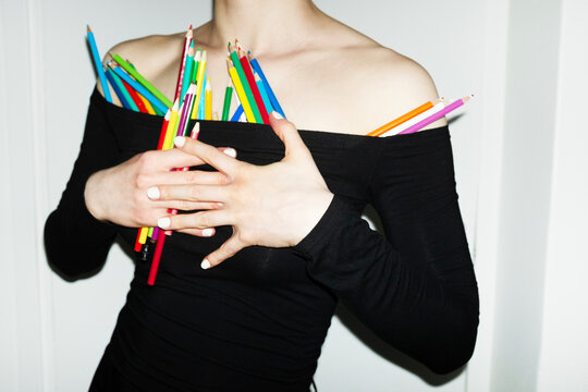 Person having colourful art drawing pencils on their off shoulder top