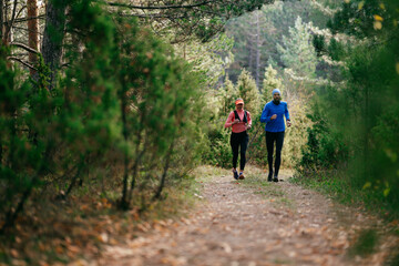 Obraz premium Happy Couple Running on a Forest Trail