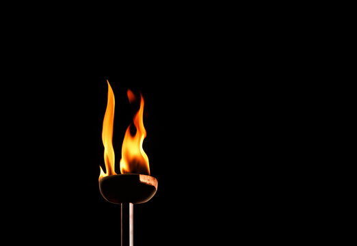 Close up burning flaming torch over black background