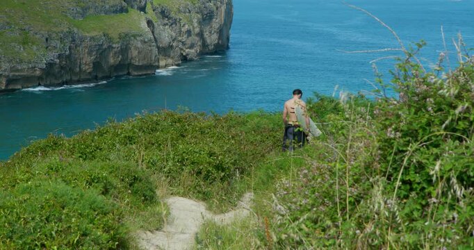 Coastal Path Wanderer: A lone figure navigates a rugged coastal path, surrounded by lush greenery and overlooking the vast expanse of the turquoise sea, a moment of solitary exploration.