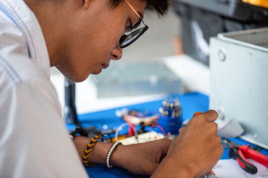 Focused student assembling electronics project.