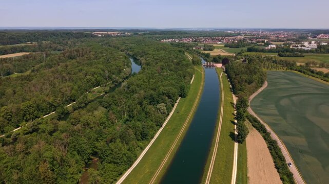 High angle establishing shot of a run-of-river plant on the Iller canal. Cinematic travel vlog asset showing eco friendly energy extraction and riverbed engineering in Southern Germany.