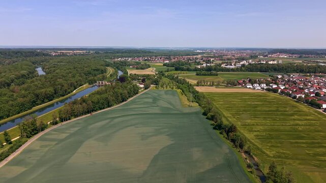 Panoramic aerial view of the Untere Iller region in Western Bavaria. Drone footage capturing the hydro power infrastructure and sustainable energy generation plants along the river canalization.
