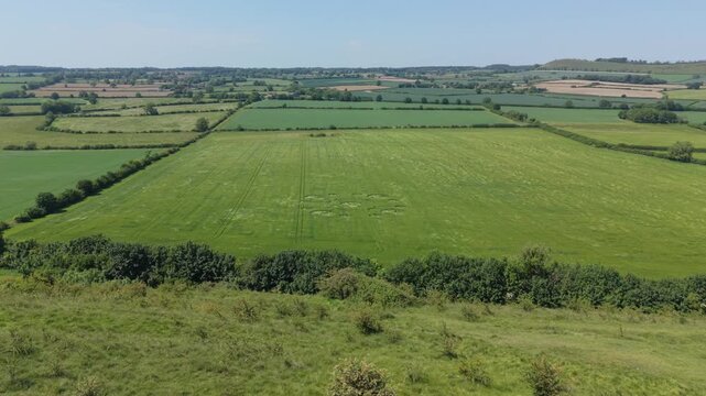 Aerial establishing footage of a mysterious, intricate, geometric crop art, crop circle formation in a barley field near White Sheet Hill, White Sheet Downs, Mere, Wiltshire, England, UK; 22 May 2026