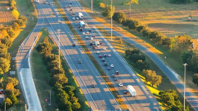 Wide multilane expressway with heavy vehicle traffic captured from above. American transportation infrastructure supporting logistics, travel and daily commuting.