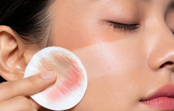 Woman using cotton pad to remove makeup from face. Asian girl cleaning skin with toner. Beauty routine, skincare concept, facial cleansing procedure, hygiene and healthcare lifestyle.