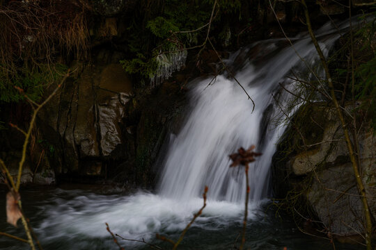 Beautiful mountain waterfall with silky smooth water in the forest. Long exposure shot of a clean stream rushing over rocks