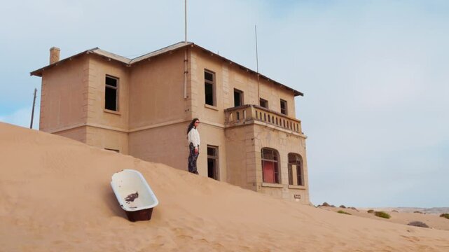 Woman visiting the abandoned town of Kolmanskop