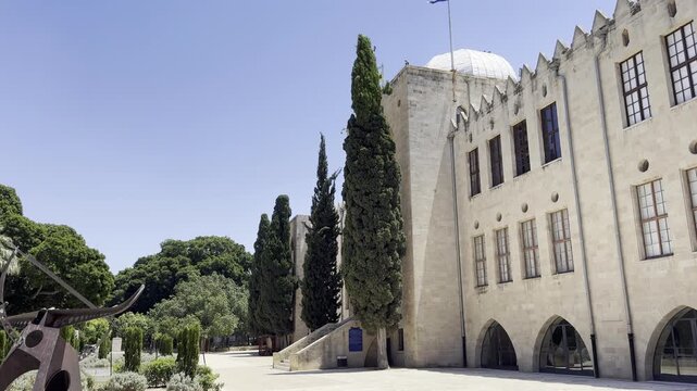 Haifa, Israel, June 12, 2026 &mdash; a view of the facade of the MadaTech Museum, the former Technion building, with cypress trees in the foreground.