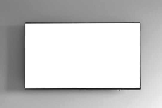 Flat screen TV with green chroma key display mounted on a gray white wall. Mockup template for displaying content or streaming video on television screen..