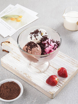 Chocolate Mousse Dessert with Fresh Strawberries and Chocolate Shavings in Elegant Glass Coupe, Cocoa Powder and Milk on Minimalist Gray Background