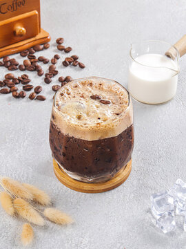 Iced Black Coffee with Creamy Foam, Roasted Coffee Beans and Fresh Milk in Glass Bottle on Minimalist Gray Background, Premium Cafe Beverage Photography
