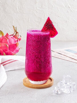 Vibrant Red Dragon Fruit Smoothie in a Clear Glass with Fresh Pitaya and Ice Cubes
