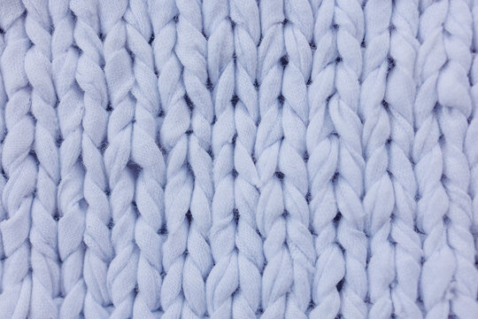 Light blue chunky knit fabric texture with large visible stitches