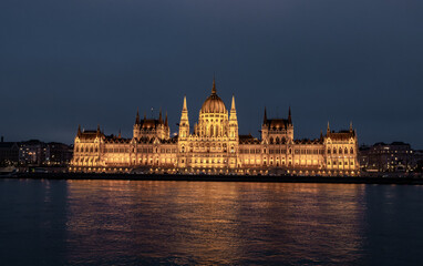 Obraz premium View from Buda Embankment of Parliament building illuminated by floodlights on a Pest embankment in Budapest in Hungary