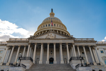 Naklejka premium Famous Capitol in Washington DC. Washington DC landmark. Senate and House in Washington DC. Capitol dome. Historic Capitol by the national flag. Capitol dome as symbol of law. Washington DC