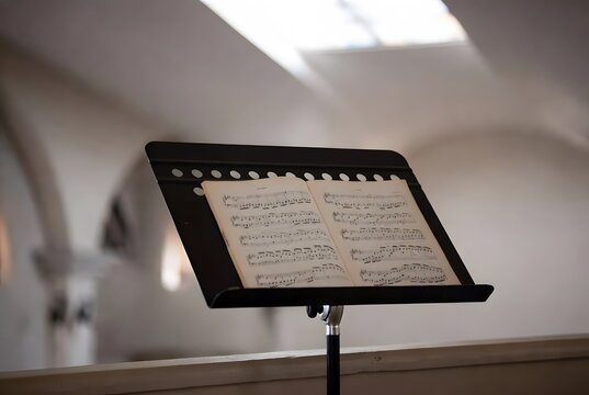 a single music stand holding an open sheet of sacred chant, evoking prayer, silence, and gentle restoration after worship