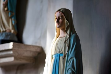 Naklejka premium a close devotional view of a simple blue Marian mantle draped over a small statue base, suggesting comfort, protection, and quiet healing