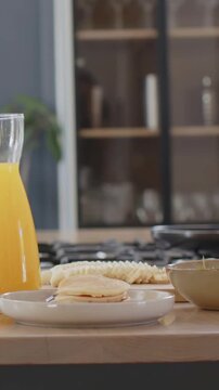 Vertical video: Panning camera revealing kitchen counter breakfast to show carafe and pancakes