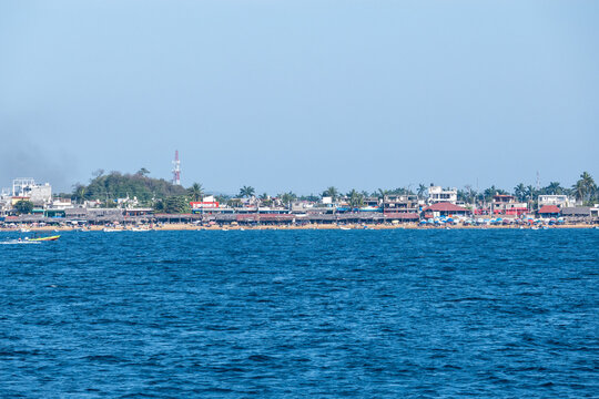 Expansive view of Acapulco Bay and the lively coastline towards Puerto Marquez. Features buildings, beach, and deep blue ocean. Perfect for travel and tourism content.