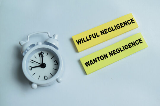 Concept of willful negligence and wanton negligence write on sticky notes isolated on Wooden Table. For severe from of reckless misconduct and involving a conscious
