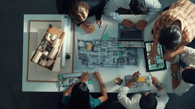 Top aerial view of project manager or civil engineer writing at blueprint and planning building design. Aerial view of architect working together at meeting table with document placed. Alimentation.