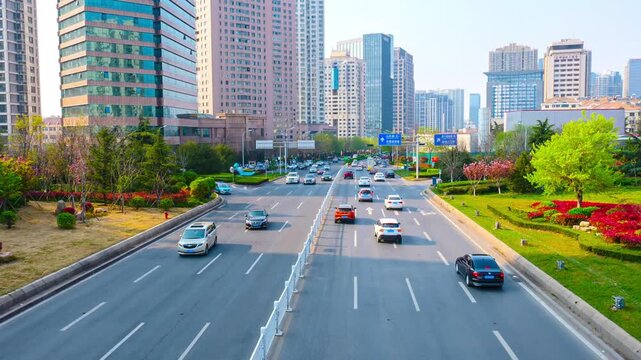 Busy urban boulevard with modern high rise buildings and spring greenery