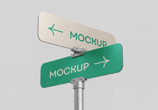 Low-angle perspective view of a metallic street signpost mockup with two directional arrows pointing left and right isolated on a solid light grey background