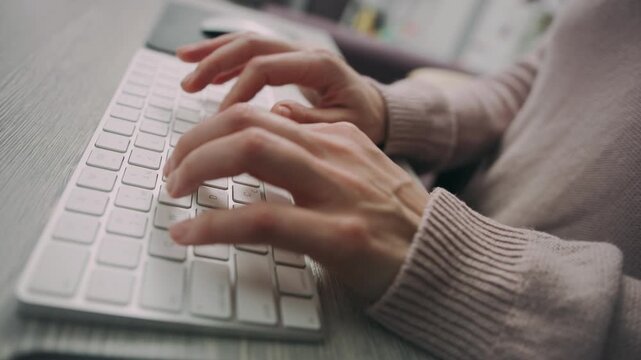 Close Up of Hands Typing on Keyboard at Desk
