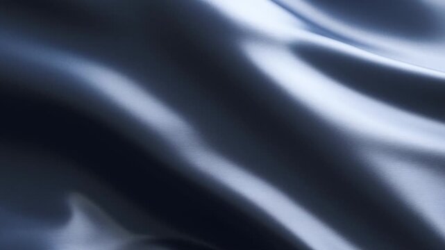Slow motion close up of silk fabric rippling and undulating across dark studio backdrop with reflective glossy sheen