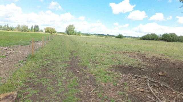 Alwalton, Cambridgeshire, UK - 09 June 2026: Point of View Walking sequence using a gimbal - across wide open farm land in the Fenland area as a storm roles in from the left, and the wind gets up.