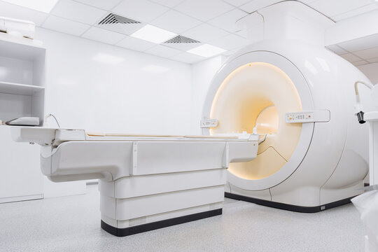 MRI scanner placed in a spacious modern radiology room with bright sterile white interior and clinical equipment. Concept medical diagnostics, imaging precision and healthcare environment.
