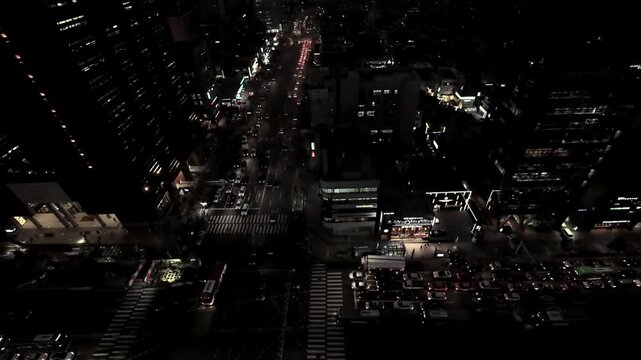 Aerial view of busy city street traffic between office buildings at dusk