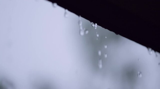 Rain Drops Falling From House Roof In Dark Stormy Extreme Weather. Climate changer, storm danger