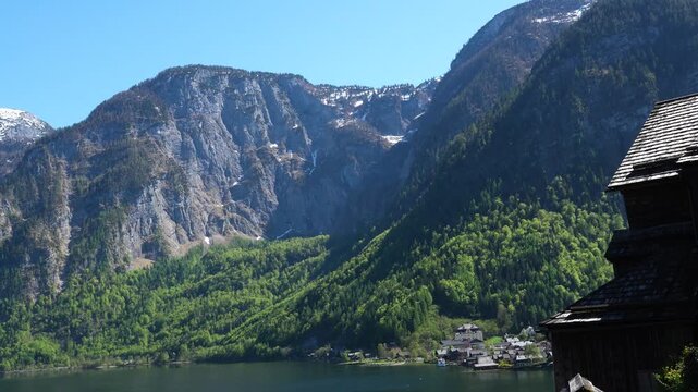 Alpine lake and mountain landscape above village rooftops