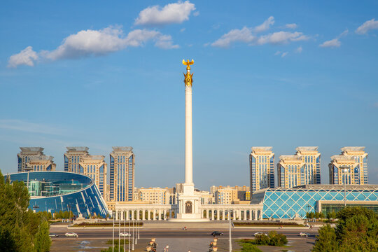 Qazaq Eli monument on Independence Square in Astana. Tall white pillar with golden eagle statue. Landmark of Kazakhstan cityscape, architecture and tourism travel destination. 08.06.25