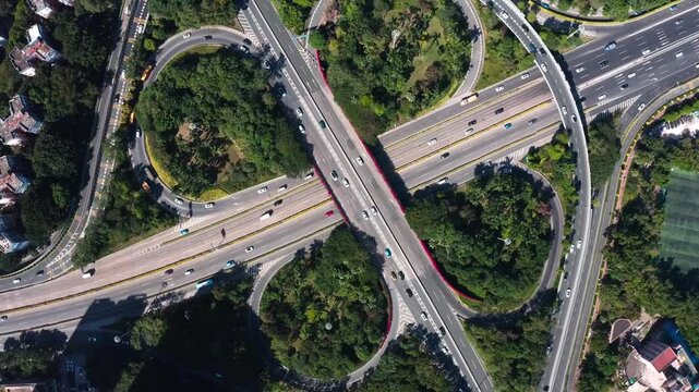 Aerial View of Cloverleaf Highway Interchange with Traffic and Green Urban Landscape
