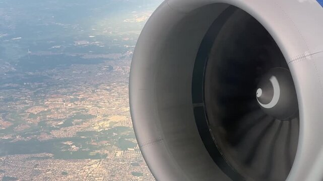 Closeup passenger window view of a modern jet engine in flight above the Japanese landscape. Air travel and aviation transportation concept. 15207  