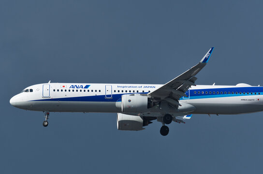 All Nippon Airways Airbus A321-200N (JA137A) on final approach to Haneda Airport against dark cloud background