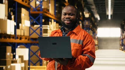 Obraz premium Portrait of male employee overseeing cargo packages for inventory in warehouse facility, E-commerce operations ensuring storage distribution for supply chain management, workforce.