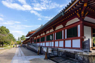 Naklejka premium Traditional wooden corridor at Todaiji Temple in Nara with historic Buddhist architecture and bright daylight in Nara, Japan 