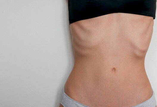 close up of a young underweight caucasian woman's stomach showing ribs