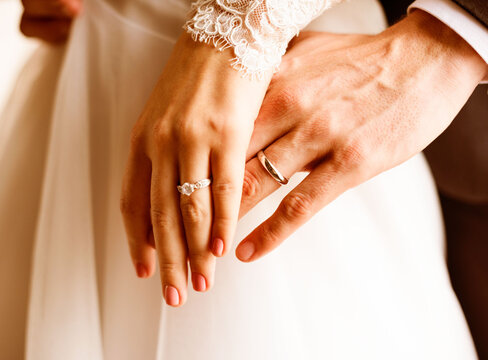 Elegant wedding rings on couple's hands
