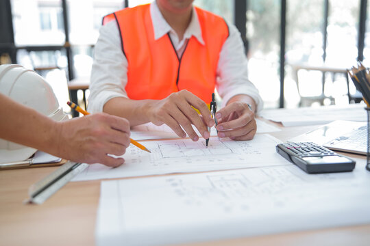 Engineers Collaborating on Architectural Plans in a Modern Office Setting