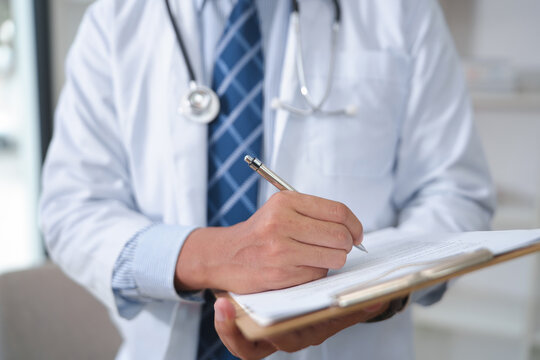 Medical Professional Writing Notes in a Clinical Setting with Stethoscope